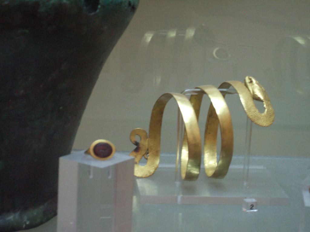 VI.12.2 Pompeii. Found 4th March 1831. Gold bracelet with body of a serpent.
Now in Naples Archaeological Museum. Inventory number 24824.
Gold ring with a virile nude figure and the inscription CAS-SIA.
Now in Naples Archaeological Museum. Inventory number 25136.