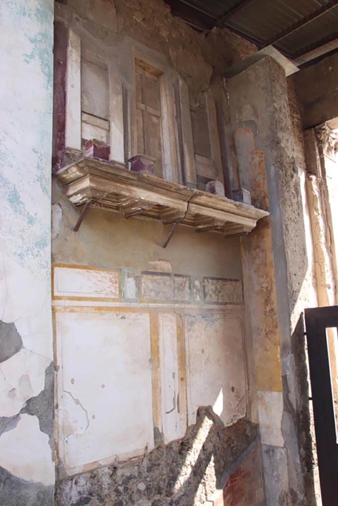 VI.12.2 Pompeii. October 2023.
Entrance fauces. East wall with shelf, on which is placed a façade with small columns.
Photo courtesy of Klaus Heese.