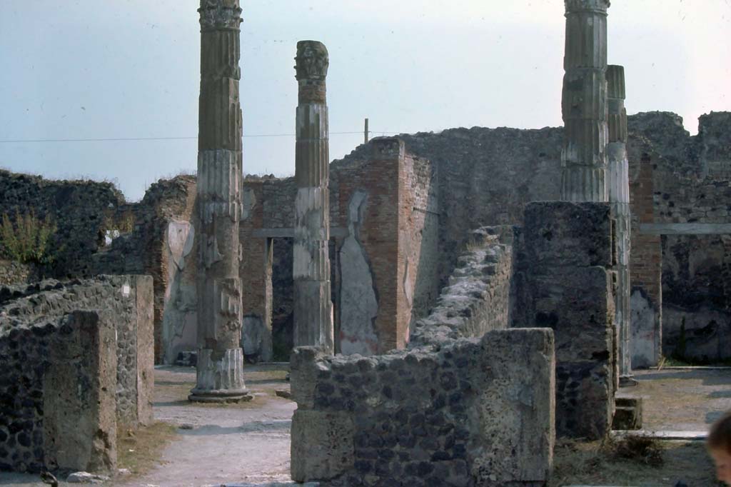 VI.12.2 Pompeii, 7th August 1976. Looking north-east towards atrium of VI.12.5.
On the left is the west ala, communicating through to atrium, on the right is a cubiculum with a doorway at either end.
Photo courtesy of Rick Bauer, from Dr George Fay’s slides collection.