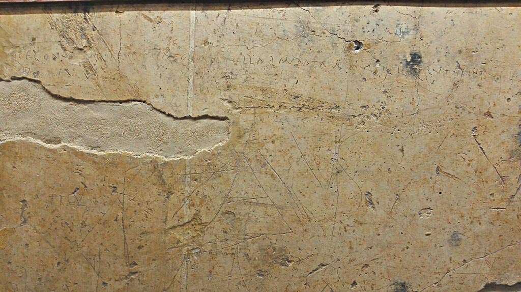 VI.14.43 Pompeii.
Graffiti from wall next to main entrance of the house. Now in Naples Archaeological Museum, inv. 4685. Photo courtesy of Giuseppe Ciaramella.
According to the information description card in Naples Museum –
Plaster fragment with scratched letters, reading –
“Here and now I copulated with a girl who is beautiful go look at and praised by many, but inside she was nothing but filth”.
(“Qui e ora ho scopato una ragazza bella d’aspetto, da molti lodata, ma dentro era soltanto fango”.)