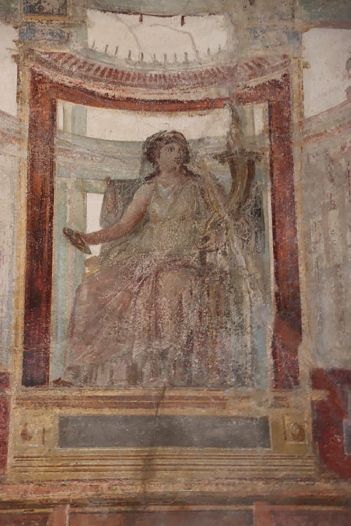 VI.15.1 Pompeii. October 2023. 
Upper east wall of exedra, detail of painted figure in centre of wall. Photo courtesy of Klaus Heese.
