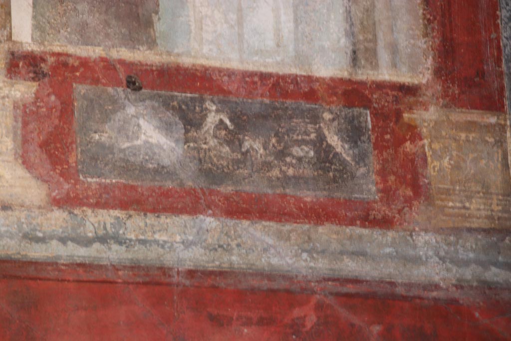 VI.15.1 Pompeii. October 2023. 
Upper east wall of exedra, painted panel below figure at south end of east wall. Photo courtesy of Klaus Heese.
