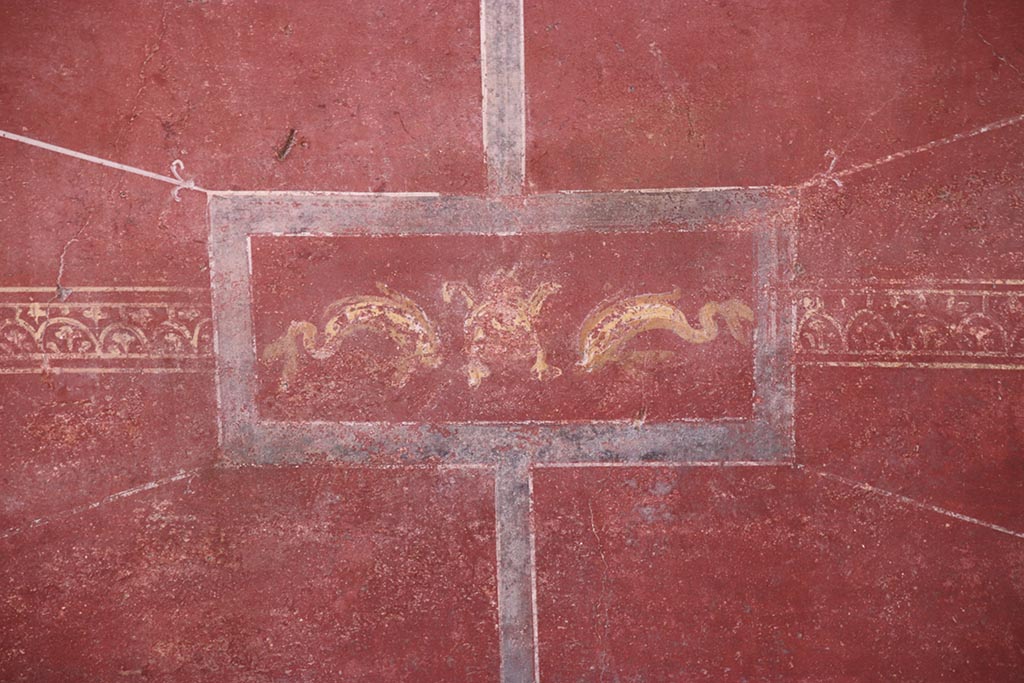 VI.15.1 Pompeii. October 2024.
Lower north wall of exedra, painted panel in centre of zoccolo beneath central painting. Photo courtesy of Klaus Heese.