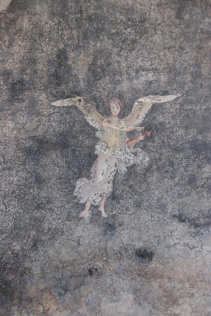 VI.15.1 Pompeii. October 2023.
Detail of painted “flying” figure panel from west wall of peristyle. Photo courtesy of Klaus Heese.