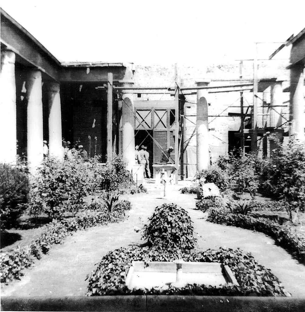 VI.15.1 Pompeii. 1944. Peristyle garden, looking north. Photo courtesy of Rick Bauer.
According to Garcia y Garcia, not even the most famous house in Pompeii was saved from the 1943 bombardment.
The troops of tourists that have visited there each day, are mostly ignorant of the reality of the events.
On the night of 16th September 1943, a bomb fell and destroyed the north-east corner of the peristyle causing the subsidence of the floor of the peristyle.
This also caused the destruction of a part of the north perimeter wall, the ruin of three columns in the peristyle, and the partial loss of the IV style painted wall from the north portico, and the west wall of the peristyle.
Damage was also suffered in the south-west part of the triclinium and the north wall of the oecus of Pasiphae, to the north-east of the peristyle.
The south corner of the women’s gynaeceum to the north of the peristyle was also partially ruined.
In the south-east corner of this area was the triclinium decorated with the painting of Hercules and Auge on the south wall.
This was damaged in its lower parts, without the possibility of restoration.
Partially damaged was the roof of the walkways around the peristyle, and that of the oecus of Pasiphae, and in the cubiculum to the north of the atrium.
The other paintings in the house were saved by a miracle.
See Garcia y Garcia, L., 2006. Danni di guerra a Pompei. Rome: L’Erma di Bretschneider. (p.93-96, including photos).