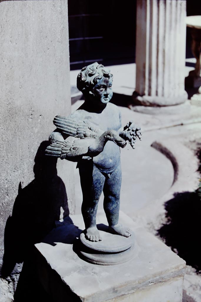 VI.15.1 Pompeii. 1968. North side of peristyle, looking east.
Bronze garden fountain statuette of boy, bird and grapes. Photo by Stanley A. Jashemski.
Source: The Wilhelmina and Stanley A. Jashemski archive in the University of Maryland Library, Special Collections (See collection page) and made available under the Creative Commons Attribution-Non-Commercial License v.4. See Licence and use details.
J68f1964