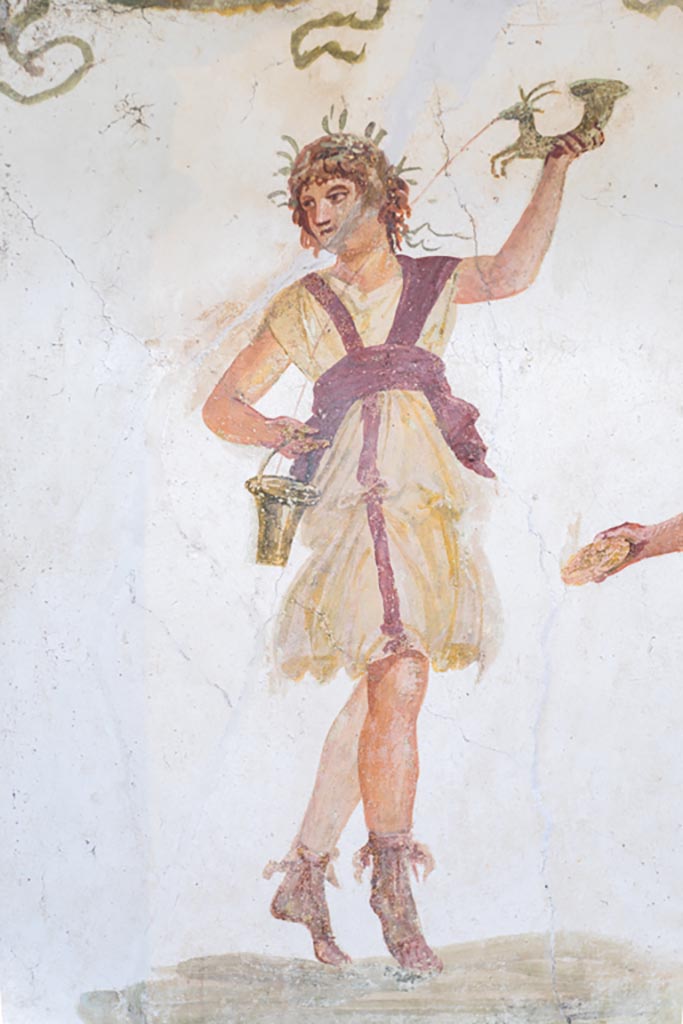 VI.15.1 Pompeii. March 2023. 
Detail of wreathed Lar holding rhyton and situla, from south end of lararium.
Photo courtesy of Johannes Eber.
