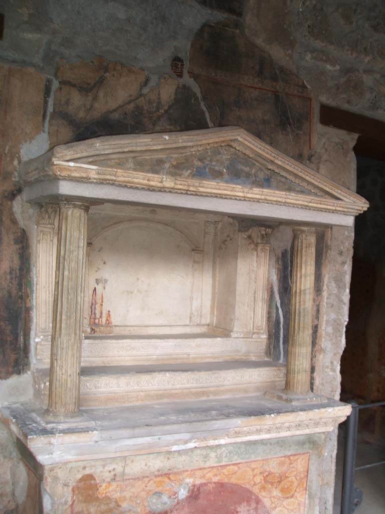 VI.16.7 Pompeii. December 2004. Room F, north portico. Household lararium.
Two fluted marble columns, with architrave and pediment.
The rectangular niche has its floor divided into three levels by two high steps (shelves).