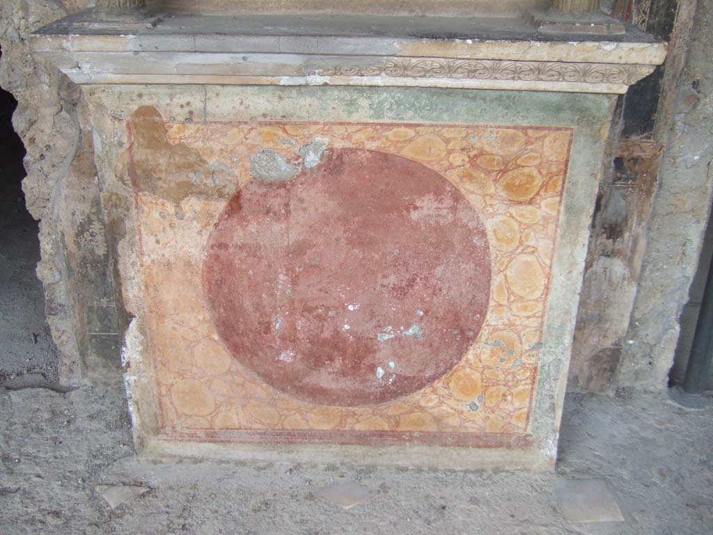 VI.16.7 Pompeii. May 2006.
Room F, north portico. Lararium podium painted to represent red and yellow marble with a darker circle in front.
