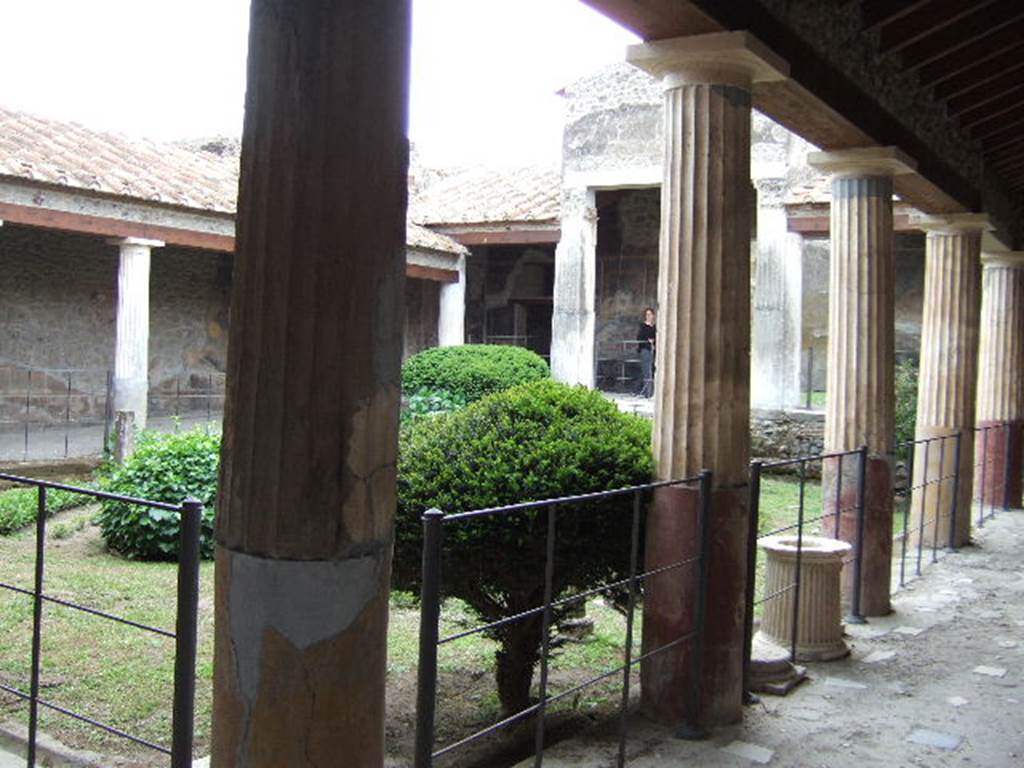 VI.16.7 Pompeii. December 2004. Peristyle garden F, looking south-west from north-east corner. According to Jashemski – The two pilasters supporting a pediment on the west side of the peristyle were white and fluted. The other columns were white and fluted above, but were painted red, and smooth below. The corner columns on the east side, together with the fourth column from the east, on the south and north sides, were painted yellow below.
See Jashemski, W. F., 1993. The Gardens of Pompeii, Volume II: Appendices. New York: Caratzas. (p.159).