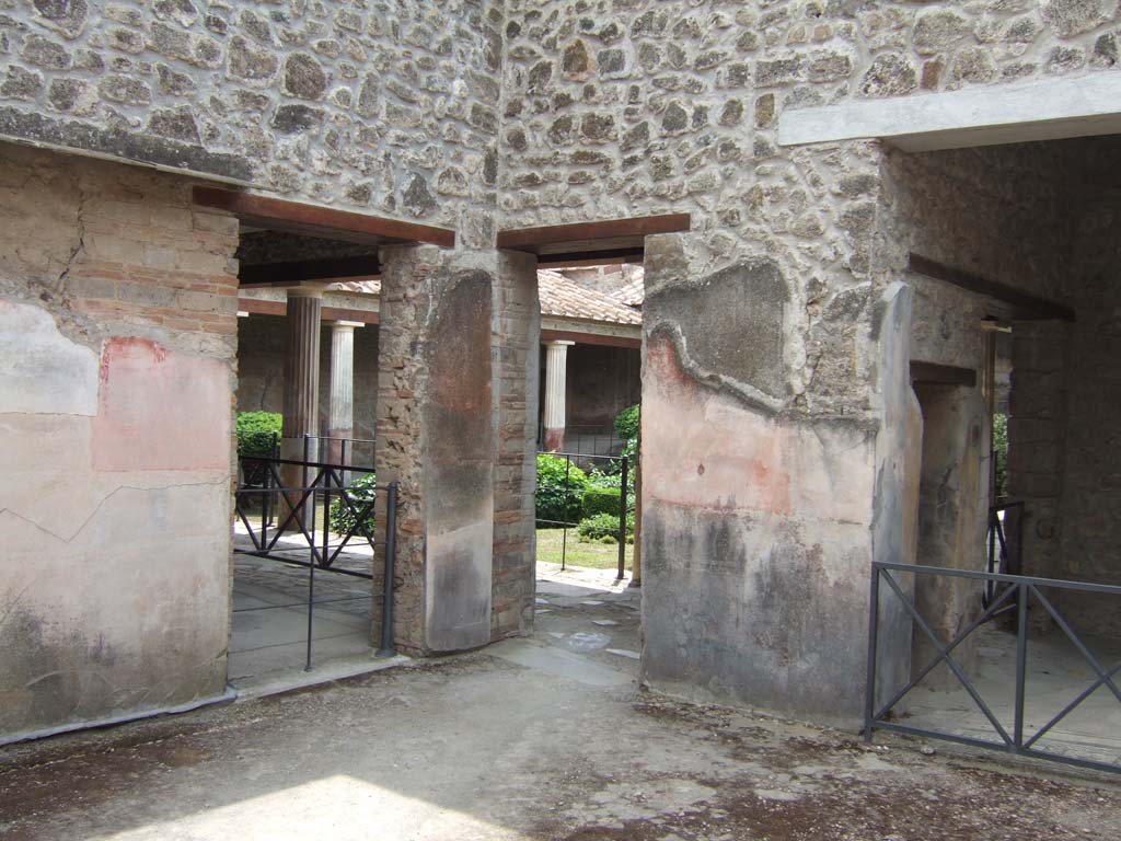 VI.16.7 Pompeii. May 2006. South-west corner of room B, atrium.
Looking towards side doorway into room G, on left, doorway to portico, in centre, and to room E, on right.