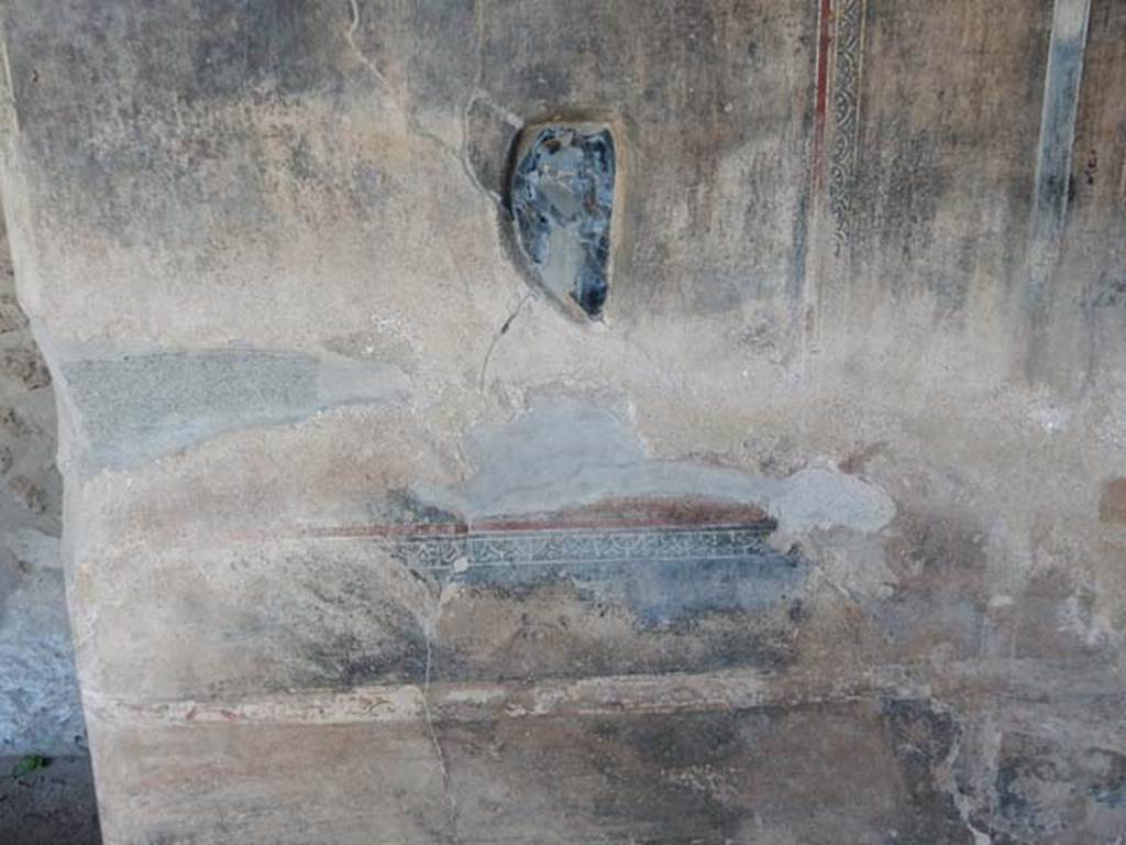 VI.16.7, Pompeii, May 2018.
Peristyle F, Obsidian mirror embedded in plaster of east wall of east portico at the southern end between the shallow space and the lararium.
Photo courtesy of Buzz Ferebee.