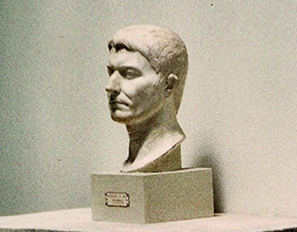 VI.16.7 Pompeii. On display in Antiquarium in August 1965. Portrait bust of an unknown male, still of young age. In the base is an iron pin, indicating that it once stood on a pilaster.
Found in the third gap in the columns of the southern portico, starting from the south-west corner.
According to PPM, the style of the portrait indicates the late-Tiberian era.
SAP inventory number 55514 or 3015. Photo courtesy of Rick Bauer.
See Notizie degli Scavi di Antichità, 1907, p. 593; fig. 41.
See Carratelli, G. P., 1990-2003. Pompei: Pitture e Mosaici: Vol. V. Roma: Istituto della enciclopedia italiana, p. 746.