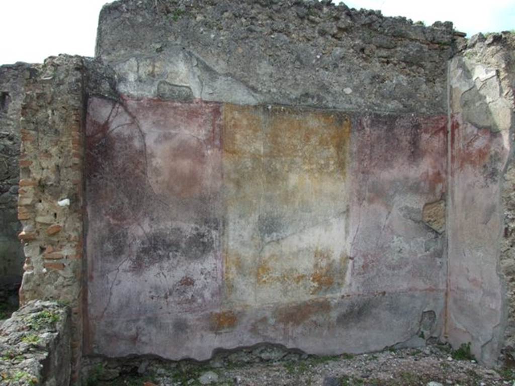 VI.16.27 Pompeii. March 2009. Room L, west wall of tablinum. According to NdS, the tablinum opened in almost its entire width from the atrium on its north side. It had wooden door jambs and maybe even a wooden threshold. The east and west walls preserved their painted decoration as well as a small wall to the left of the wide northern doorway. Each wall showed three large panels, the central yellow, the sides red. These were best preserved on the west wall, where on the yellow central panel was a painting of Atalanta and Meleager. The painting was very poorly preserved. On the left was Atalanta sitting on a chair, on the right was Meleager. Near to him on the left was a dog resting on its back legs, with its head pointing towards its master. Between the dog and Atalanta, the boar, profiled to the right, was on the floor. In the middle of the two red panels of the west wall were small landscapes, without frames, and very faded. The portion of the north wall, to the left of the large doorway to the atrium, offered a red panel with the painting of a mask in the centre.
On the white frieze, were the usual architecture with suspended objects and arabesques.
The badly preserved dado on a black background was divided into panels by means of reddish bands. See Notizie degli Scavi, 1908, (p.189)