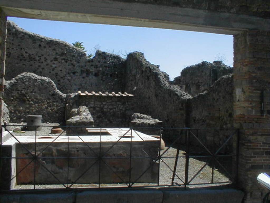 VI.16.40 Pompeii. May 2005. Looking south-east from entrance doorway towards corridor E on south side. The room F was lit by a window in the southern wall, and was reached by the corridor E. According to Boyce, in the room reached by the corridor leading from the bar-room, was a lararium painting. It was on a large panel on the west wall bordered with broad stripes, yellow at the sides, red at the top. Within were painted two serpents confronted at a cylindrical altar. The serpents were of a brownish colour and each had a red crest and beard, both larger on the one on the right. The altar was tiny in comparison with the serpents, and was painted in imitation of red and yellow marble. On the top of the altar were two eggs and a pine cone. Below the painted altar, a tile was embedded in the wall to hold the offerings. The background was profusely adorned with green plants and red flowers. Across the top of the panel was stretched a triple festoon, upon the middle of which perched a bird. See Notizie degli Scavi di Antichità, 1908, 370. See Boyce G. K., 1937. Corpus of the Lararia of Pompeii. Rome: MAAR 14. (p.59, no.230, and Pl.27,1) See Fröhlich, T., 1991. Lararien und Fassadenbilder in den Vesuvstädten. Mainz: von Zabern. (L77, Picture 9,2 from the west and north walls)
.