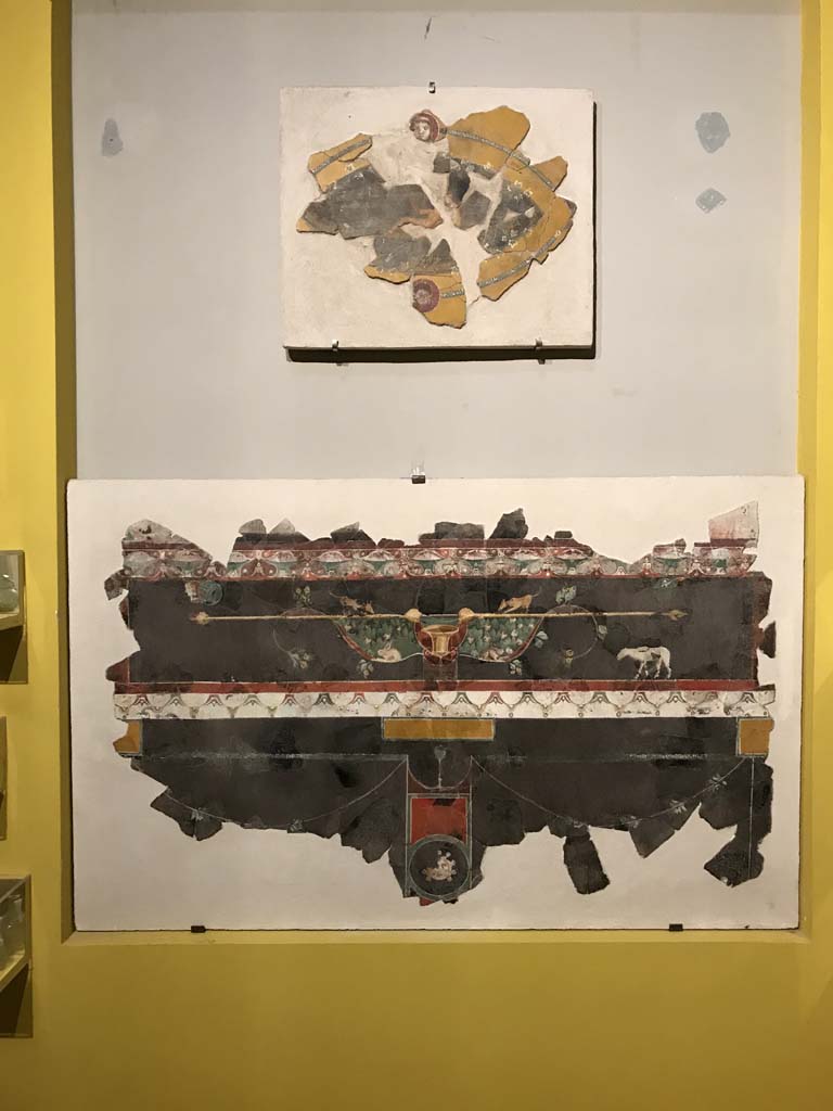 VI.17.42 Pompeii. April 2019. Fragments of III Style decoration photographed on display in Antiquarium.
These fragments were found in 1983, together with numerous others, in the garden area.
They were from a room damaged following the 62AD earthquake
Top: Oval fragment of Satyr and Maenad from upper zone of a wall.
Lower: Fragment of predella on black background (PAP inventory number 86078)
Photo courtesy of Rick Bauer.
See Aoyagi M. and Pappalardo U. et al, 2006. Pompei (Regiones VI-VII) Insula Occidentalis, I. Napoli: Valtrend. (p.222 and 244, and 248).