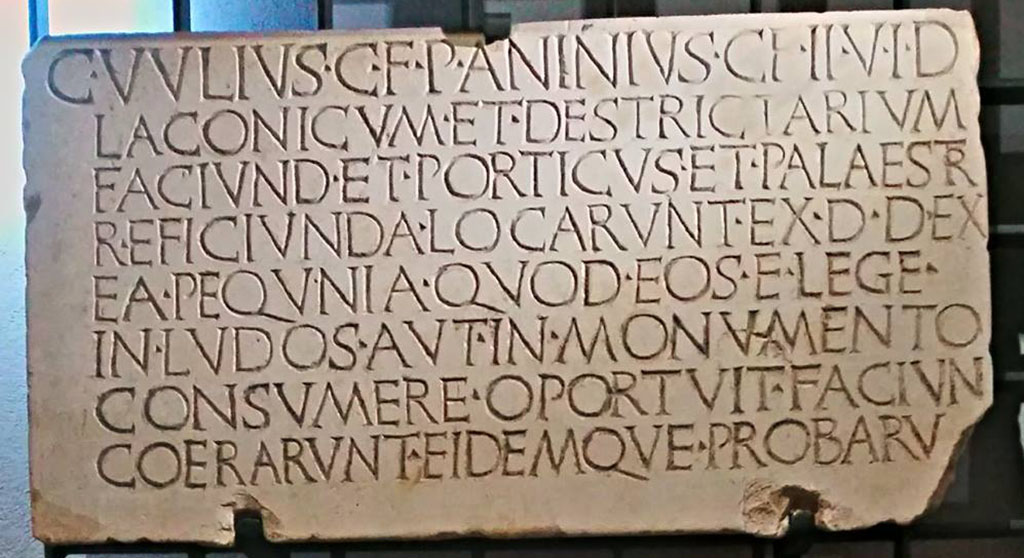 VII.1.8 Pompeii. Dedication for the renovation of the Stabian Baths, post 70BC.
Photo courtesy of Giuseppe Ciaramella.
Now in Naples Archaeological Museum, inv. no. 3826 (CIL X, 829).
According to the information card –
“The duoviri with judicial powers Gaius Uulius, son of Gaius, and Publius Aninius, son of Gaius, contracted out, by decree of the decurions, the construction of the sweat baths and the exercise room (destrictarium), and the rebuilding of the porticoes and the gymnasium. With the money which, by law, they were required to spend for games or a monument, they had (them) built, and inspected (them) themselves”.
The enlargement of the Stabian Baths was financed by the colony, as its statute prescribed. One of the two magistrates, Gaius Uulius, was from a local family, whereas the family of Publius Aninius was originally from southern Latium and belonged to the first generation of Sullan colonists.
(I duoviro giusdicenti Gaio Uulio, figlio di Gaio, e Publio Aninio figlio di Gaio appaltarono per decreto dei decurioni la costruzione del sudatorio e dell’ambiente per gli esercizi (destrictarium), e la ricostruzione dei portici e della palestra; con quel danaro che, per legge, essi dovevano spendere per i giochi o per un monumento, fecero costruire ed essi stessi collaudarono.)
L’ampliamento delle Terme Stabiane è finanziato per statuto della colonia. Dei due magistrati Gaio Uulio è di famiglia locale, mentre quella di Publio Aninio proviene dal Lazio meridionale e appartiene alla prima generazione dei coloni sillani.