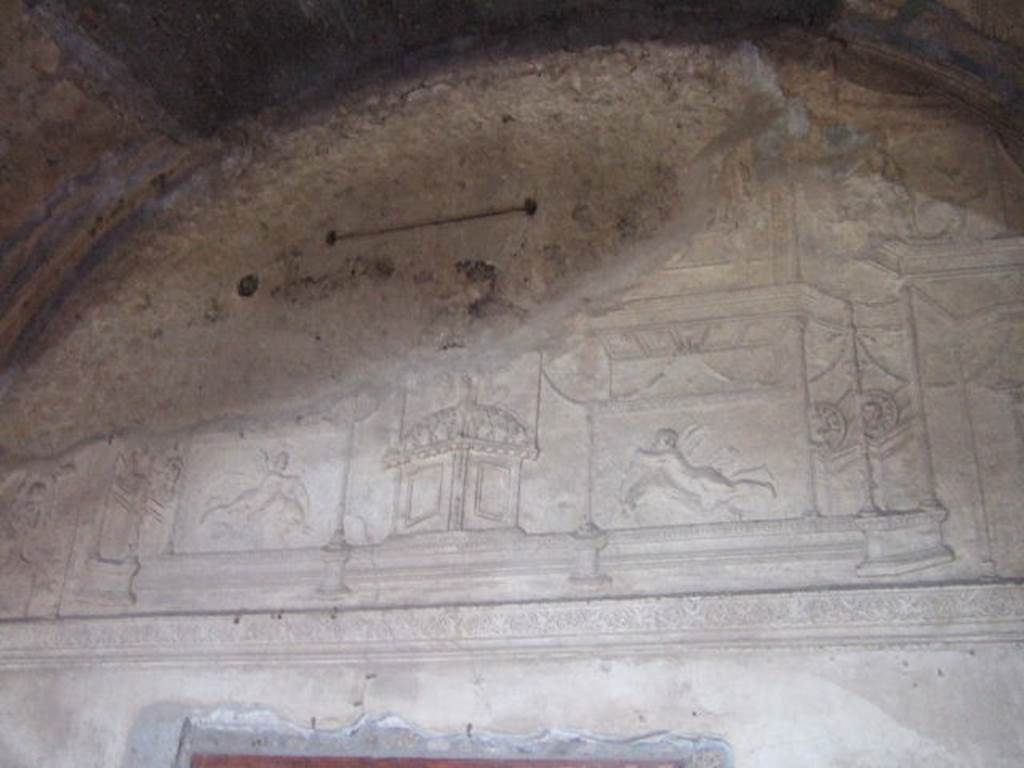 VII.1.8 Pompeii. September 2005. Detail of plaster on east end wall of men’s changing room 2, above doorway to waiting room 2a.