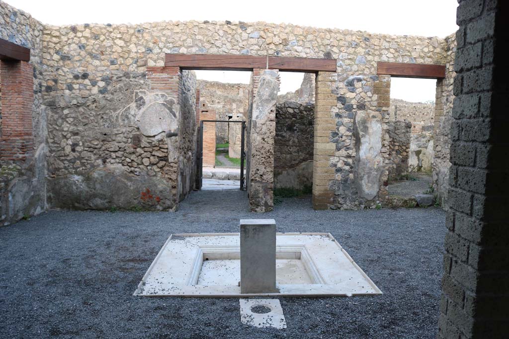 VII.1.25, Pompeii. December 2018.
Looking east across impluvium in atrium 24 to fauces 23 and entrance VII.1.25. Photo courtesy of Aude Durand.