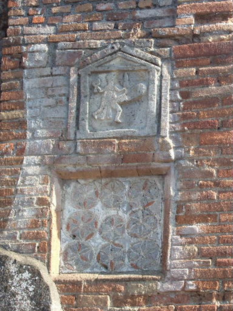 VII.1.36 Pompeii. June 2019.  
Phallus and rhomboid plaques outside VII.1.36 Modestus Bakery, on pilaster on west side of entrance doorway.
Photo courtesy of Buzz Ferebee.
