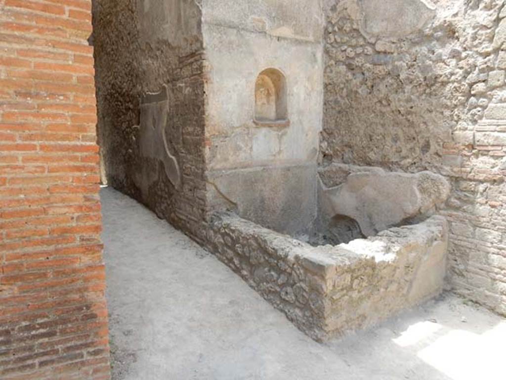 VII.1.46 Pompeii. May 2017.
Looking north-west across kitchen 12 to niche lararium 14 built into west wall above a basin/tank.
On the left is the corridor with a small niche in its north wall.
Photo courtesy of Buzz Ferebee.