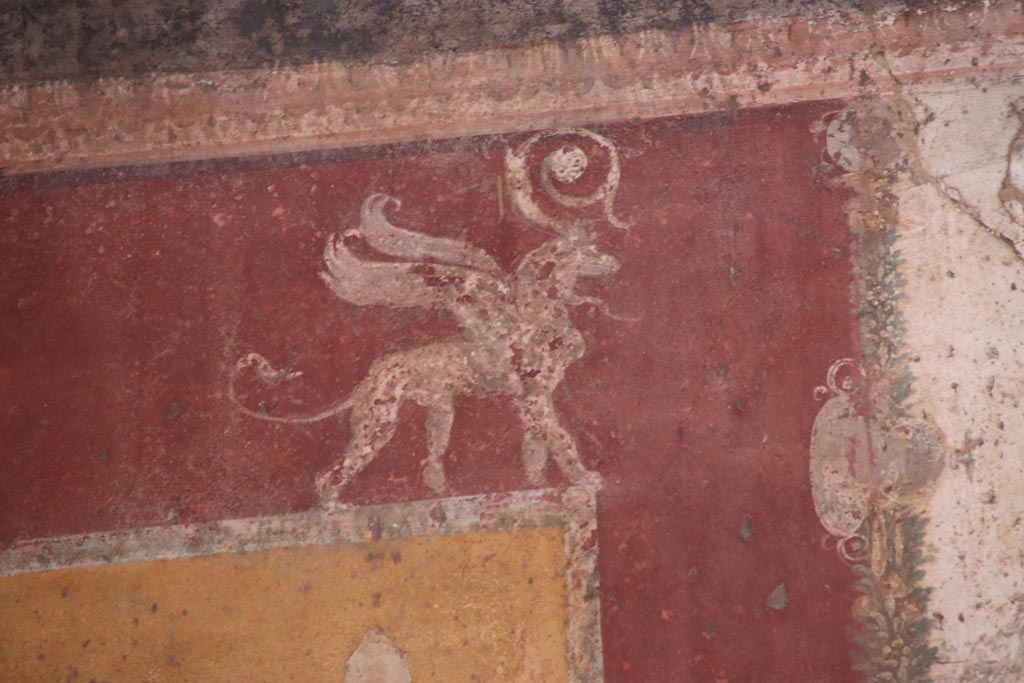 VII.1.47 Pompeii. October 2023
Exedra 10, detail of painted griffin, from upper west end of north wall. Photo courtesy of Klaus Heese.