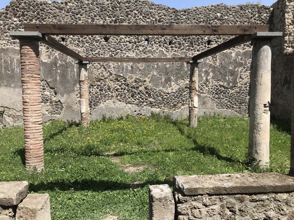 VII.1.47 Pompeii. April 2019. Looking east across site of shaded triclinium in peristyle 19. Photo courtesy of Rick Bauer.
According to Jashemski –
“The four small columns in the garden probably supported a pergola which shaded a wooden triclinium.
An elegant triclinium (b) (now room 8) to the left of the passageway leading to the peristyle had a wide window opening into the west portico, giving a good view into the garden. The window could be closed with four vertical folding leaves”.
See Jashemski, W. F., 1993. The Gardens of Pompeii, Volume II: Appendices. New York: Caratzas. (p.171).