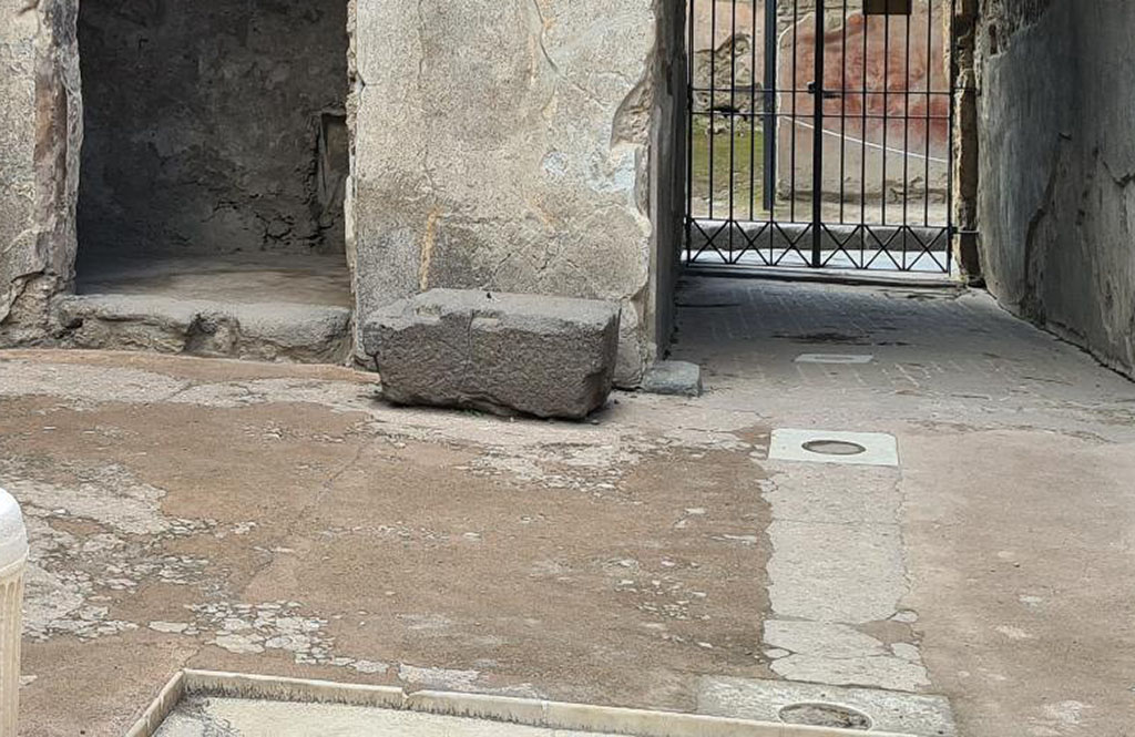 VII.1.47 Pompeii. October 2024. Money chest base in atrium 3.
Doorway to cubiculum 4, left, with base of money-chest separating it from entrance corridor/fauces, right.
Photo courtesy of Klaus Heese.