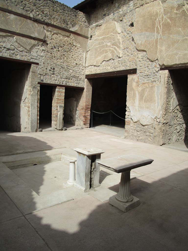 VII.1.47 Pompeii. April 2019. Looking north-west across atrium 3.
On the left is the east end of the entrance corridor, then the two doorways belong to the room on west side of atrium.
The doorway to Exedra 10 can be seen in the centre.
The doorway on the right leads into the corridor 9, to the kitchen area in VII.1.46.
Photo courtesy of Rick Bauer.
