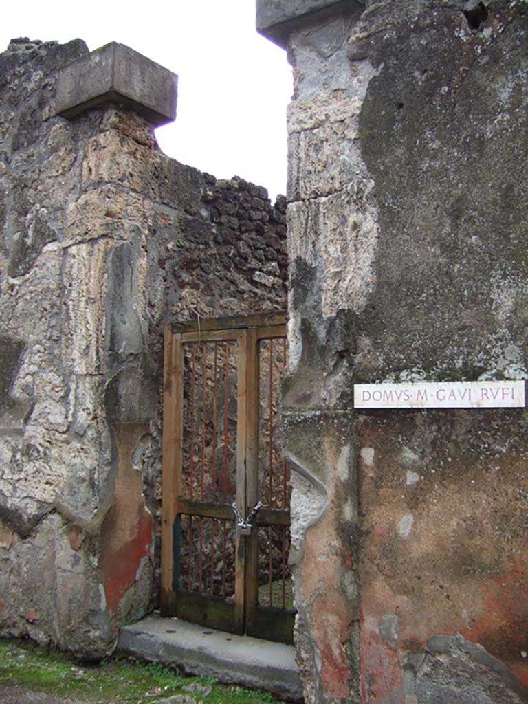 VII.2.16 Pompeii. December 2005. Entrance, with cubic tufa capitals.
Della Corte thought that the identification of the owner of this house as being M. Gavi Rufi should be rejected.
The identification was based on two inscriptions found on the red plaster at the sides of the doorway
M. GAVI. DOMVS    on the left, and
RVFII VA(le)   [CIL IV 2319f]  on the right between VII.2.16 and VII.2.17.
Therefore, he said, this house owner should remain anonymous.
Fiorelli thought these inscriptions gave the ownership of the house, without doubt, to duumvir M. Gavio Rufo.
See Della Corte, M., 1965. Case ed Abitanti di Pompei. Napoli: Fausto Fiorentino. (p.154)
See Pappalardo, U., 2001. La Descrizione di Pompei per Giuseppe Fiorelli (1875). Napoli: Massa Editore. (p.81)

Also found on the wall of the house, according to Cooley,
Marcus Vecilius Verecundus, outfitter.  [CIL IV 3130]
See Cooley, A. and M.G.L., 2004. Pompeii: A Sourcebook. London: Routledge. (p.176, H55)
According to Della Corte, the graffito was found on a column in the house:
M. Vecilius Verecundus, Vestiar(ius)      [CIL IV 3130]
See Della Corte, M., 1965. Case ed Abitanti di Pompei. Napoli: Fausto Fiorentino. (p.280)

Also found on the wall between VII.2.16 and shop at VII.2.17,
Vesbinus cinedus, Vitalio pedicavit     [CIL IV 2319b]
See Varone, A., 2002. Erotica Pompeiana: Love Inscriptions on the Walls of Pompeii, Rome: L’erma di Bretschneider. (p.137)
