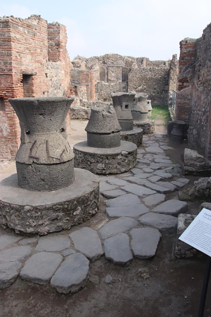 VII.2.22 Pompeii. October 2023.
Looking east towards mills in bakery from entrance doorway. Photo courtesy of Klaus Heese.