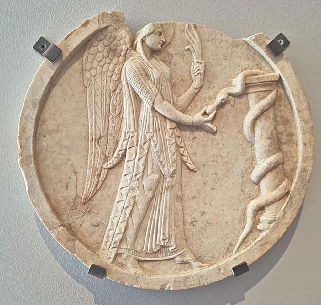 VII.4.59 Pompeii. October 2023. Peristyle o, double sided oscillum (side A) with winged Victoria.
Marble decorative hanging relief (oscilla) showing a winged Victory, inv. 6552. Photo courtesy of Giuseppe Ciaramella.
On display in “L’altra MANN” exhibition, October 2023, at Naples Archaeological Museum.