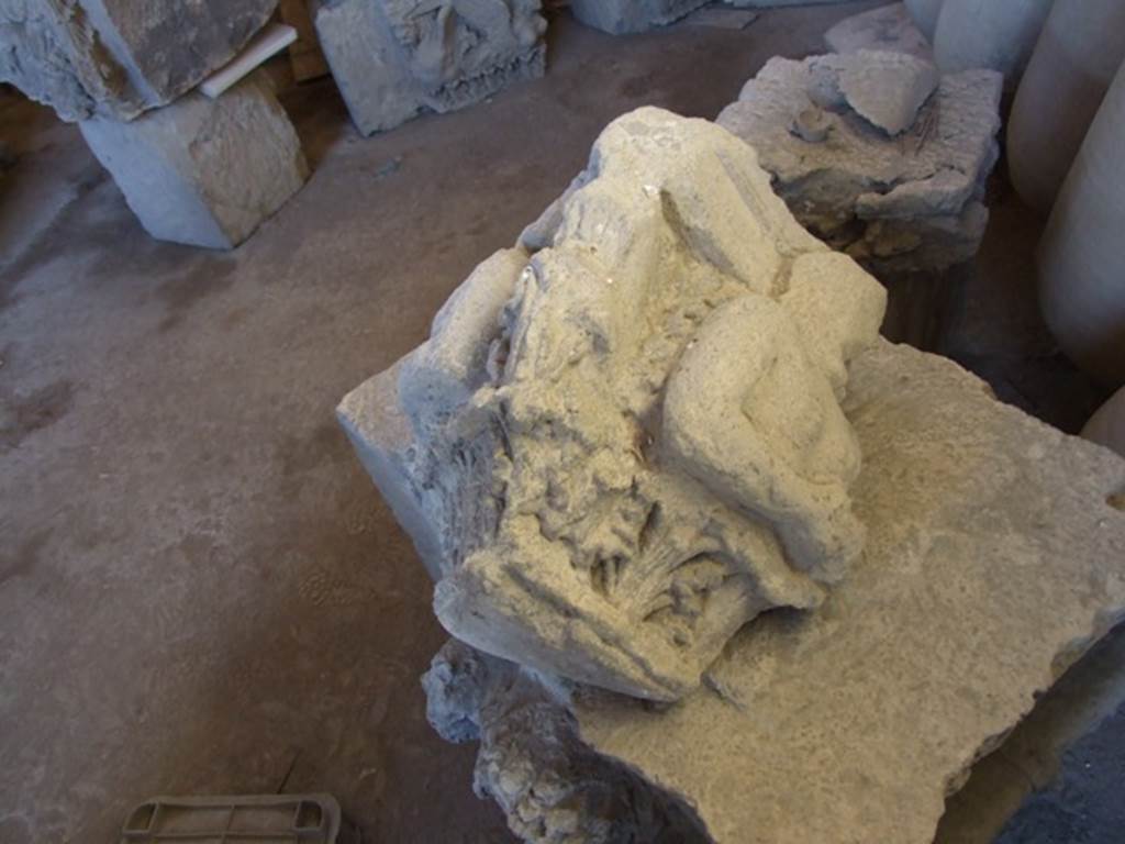 VII.4.59 Pompeii. December 2006. Remains of a capital in storage in the Forum Granary store VII.7.29. This damaged capital of Nocera tufa was found lying abandoned in a room of VII.4.59. Spano suggested it may have been the capital from the right side of the entrance of the House of Ariadne. The above photo shows the side that would have been pointing onto the Via della Fortuna. See Notizie degli Scavi di Antichità, 1910, p.280 and p.282, fig. 12.