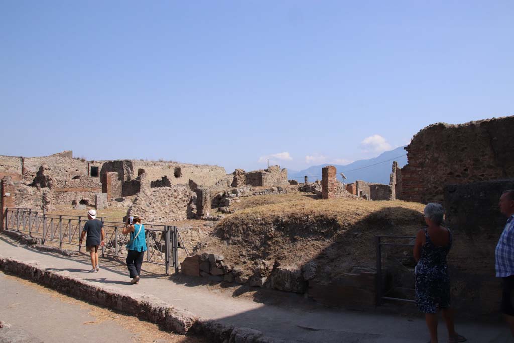 VII.6.3, Pompeii, doorway left of centre, next to person in turquoise. September 2019. 
Looking south-east across VII.6 on south side of Via delle Terme, from junction with Vicolo del Farmacista, on right.
VII.6.2 would be the doorway under the mound of soil, centre right, followed by doorway of VII.6.1, on right.
Photo courtesy of Klaus Heese.

