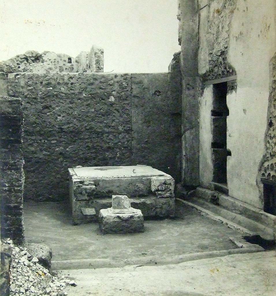VII.6.3 Pompeii. 1910. Room 18, viridarium in south-west corner of the peristyle.
Base of a Temple Lararium shrine (r) with a small altar in front.
According to Jashemski,
“Professor Richardson has shown that the well-known archaic statue of Diana, (Mus. Naz. Inv. No. 6008) which was found at Pompeii in 1760, came from the large and elegant shrine in the south-west part of the garden. There was a tufa altar in front of the shrine”.
See Jashemski, W. F., 1993. The Gardens of Pompeii, Volume II: Appendices. New York: Caratzas. (p.184).
Photograph courtesy of Soprintendenza Speciale per i Beni Archeologici di Napoli e Pompei.