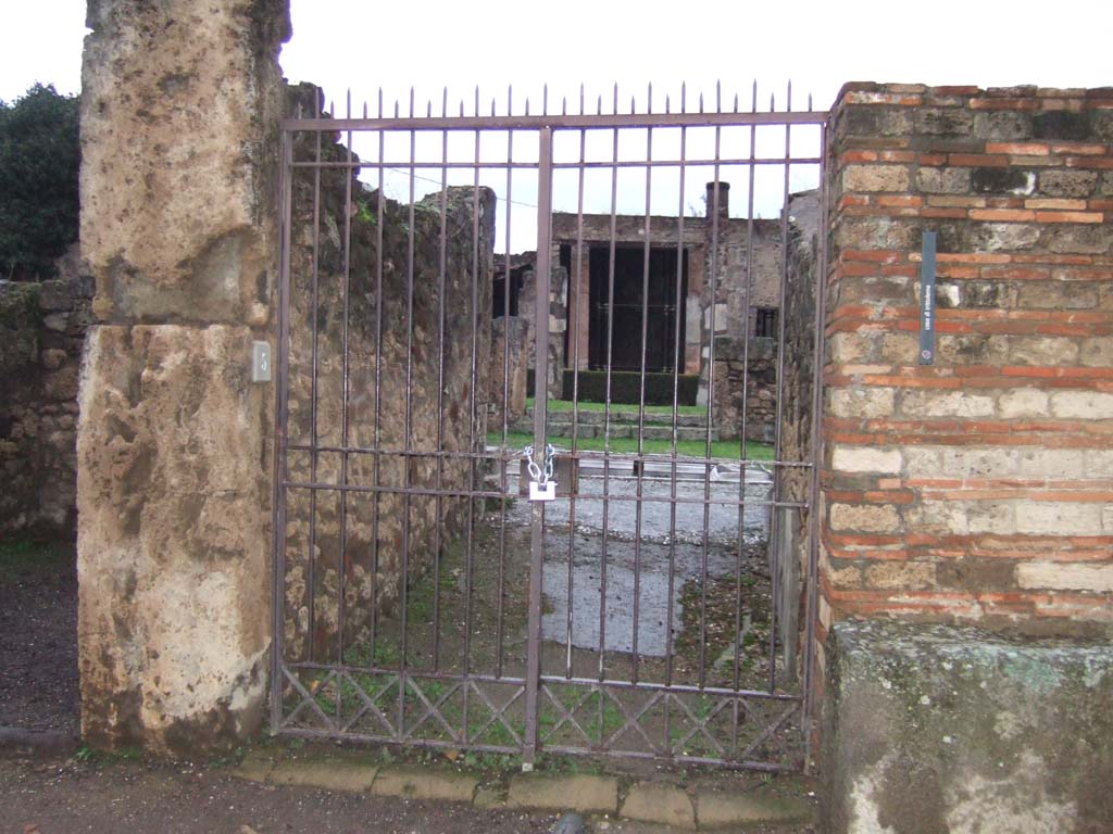 VII.7.5 Pompeii. December 2005. Looking north to entrance doorway into fauces (a).
Little remains of the floor which consisted of a mixture of lavapesto interspersed with large marble chips.