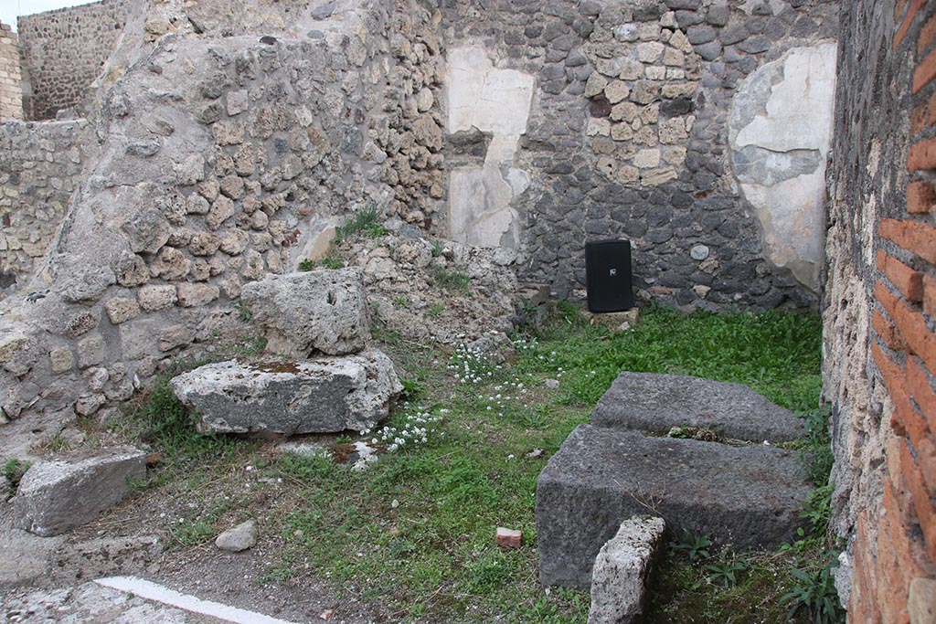 VII.7.5 Pompeii. October 2024.
Looking east to room (f), and south-east corner of atrium, with base of money-chest (arca), on right. Photo courtesy of Klaus Heese.