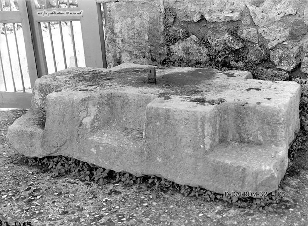 VII.7.5 Pompeii. 1932. Base for strong-box/money chest, found on west side of entrance doorway in atrium.
According to Pernice –
Chest base. Found in the atrium, to the left of the entrance.
At the four corners of this travertine base there are notches for square post feet.
At the front there is another shallow notch, so that the chest must have stood on 3 feet at the front.
At the front edge of the surface there is an iron spike for fastening the chest.
See Pernice, E., 1932. Hellenistische Tische, Zisternenmündungen, Beckenuntersätze, Altäre u. Truhen. Berlin, p. 73, Taf. 44.1.
DAIR 32.1105. Photo © Deutsches Archäologisches Institut, Abteilung Rom, Arkiv.
Thanks to Espen B. Andersson for assisting us in our interest in money-chests.
