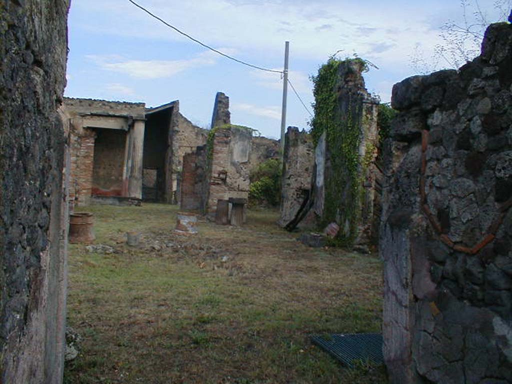 VII.7.10 Pompeii. September 2004. Looking north-east across atrium, from entrance fauces.
According to Della Corte, near the oecus (n) on the east side of the tablinum, skeletons of two men, a boy and two dogs were found.
One of the adult skeletons had a gold ring on a finger on his left hand, and another of bronze with the wording FA-H. He also had a lot of money on him.
Della Corte without hesitation interpreted his name as Fa(bius) H…….
See Della Corte, M., 1965. Case ed Abitanti di Pompei. Napoli: Fausto Fiorentino. (p.218, S.43 = C.X.8058)