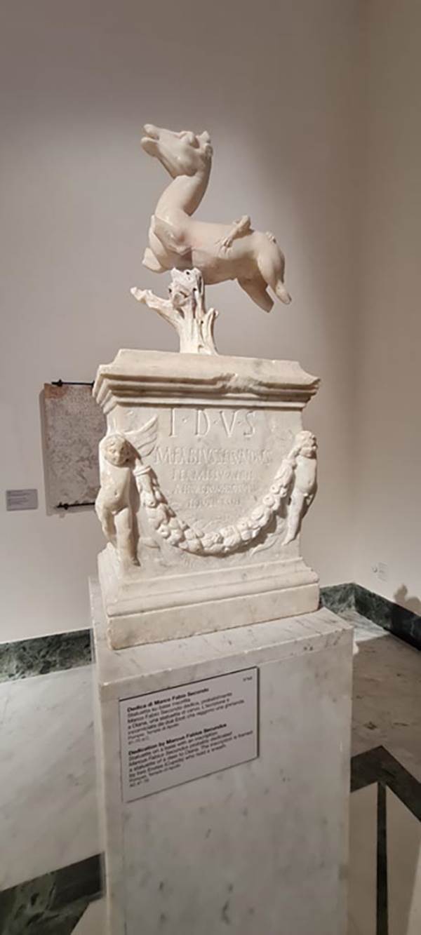 VII.7.32 Pompeii. April 2023.
Statuette on a base with an inscription on display in “Campania Romana” gallery, inv.3762.
Photo courtesy of Giuseppe Ciaramella.