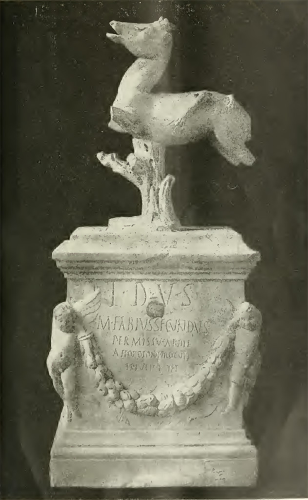 VII.7.32 Pompeii. Inscribed statue and base found 25th March 1817.
Now in Naples Archaeological Museum. Inventory number 3762.
Secondo Tarallo, trattasi di una basetta di marmo alta mm. 380, lunga mm. 340 e larga mm. 235. Nella parte anteriore, ai due angoli, sono rilevati due graziosi puttini o amorini che sostengono un festone di fiori e frutti. Tra la cornice superiore della basetta, ed il festone v'è incisa la seguente iscrizione:
T D V S
M FABIVS SECVNDVS
PERMISSV AEDIL
A HORDIONI PROCVLI
TI IVLI RVFI
Nella parte posteriore, ai due angoli, sono scolpiti a rilievo due uccelli, sulle due facce laterali pendono due altri festoni di foglie. Sormonta la basetta un quadrupede con le gambe stroncate, il quale è sorretto da un tronco d'albero. Sul dorso di esso si osservano i vesti di quattro zampe di un altro animale che gli è saltato addosso per dilaniarlo. Il tutto, compresa la base, è alto mm. 710.
Parecchi studiosi presero ad esaminare il donarlo: ognuno manifestò la propria opinione; ma, poiché non si fu sempre di accordo nel determinare la divinità, a cui appartenesse il tempio, ove era stato rinvenuto, ne segni che non si fu sempre d'accordo nel determinare il nume, a cui quello fosse consacrato. Questa varietà d'opinioni proveniva dal fatto, che proprio il nome del nume era celato sotto le sigle T-D-V-S.
According to Tarallo, this is a marble base 380mm high, 340mm long and 235mm wide. In the front, at the two corners, there are two graceful cherubs or cupids holding up a festoon of flowers and fruit.
Between the upper frame of the base and the festoon there is the following inscription:
T D V S
M FABIVS SECVNDVS
PERMISSV AEDIL
A HORDIONI PROCVLI
TI IVLI RVFI
On the back, at the two corners, two birds are sculpted in relief, on the two side faces hang two other festoons of leaves.
The base is surmounted by a quadruped with its legs missing, which is supported by a tree trunk.
On its back are the vestiges of four legs of another animal that jumped on it to tear it to pieces.
The whole, including the base, is 710 mm high.
Several scholars began to examine the donation: each expressed his opinion, but, since they were not always in agreement in determining the deity, to whom the temple belonged, where it was found, they were not always in agreement in determining the deity, to whom it was consecrated. This variety of opinions stemmed from the fact that the very name of the deity was hidden under the initials T-D-V-S.
Vedi/See Tarallo, E. Intorno al Donario del Pompeiano Marco Fabio Secondo in Rendiconti (Lincei) della Classe di scienze morali, storiche e filologiche, s5, v21, 1912, p. 69-78 and Tav. p. 78.