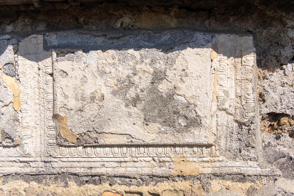 VII.7.32 Pompeii. October 2023.
Detail of remaining decorative stucco from upper west wall of cella. Photo courtesy of Johannes Eber.