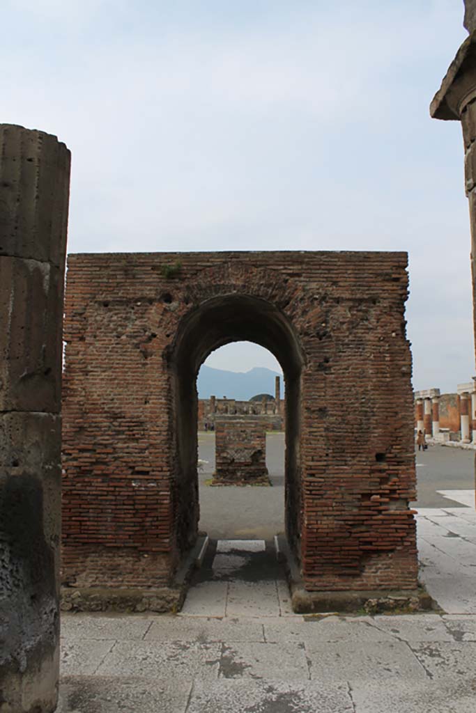 VII.8 Pompeii Forum. March 2014.
Looking north through arched monument of Augustus to base for statue of Nero.
Foto Annette Haug, ERC Grant 681269 DÉCOR.