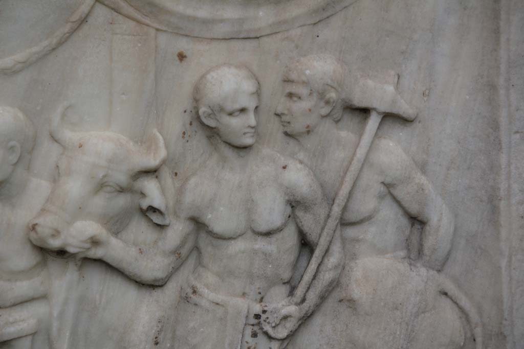 VII.9.2 Pompeii. April 2014. Detail from west side of Altar. Photo courtesy of Klaus Heese.
According to Mau, these figures are the victimarius or slayer and an assistant who are bringing a bull to the altar for sacrifice.