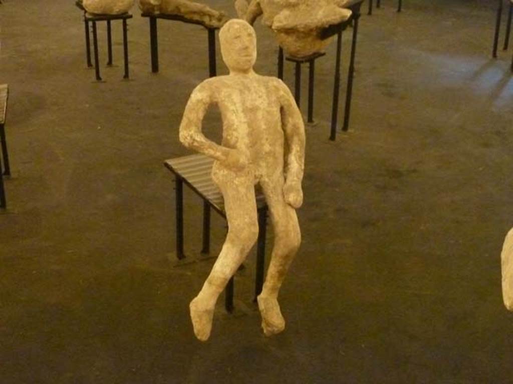 VII.16.17-22 Pompeii. September 2015. Exhibit from the Summer 2015 exhibition in the amphitheatre. Plaster cast of a body found huddled together with the others on the stairs that led to the ground floor.