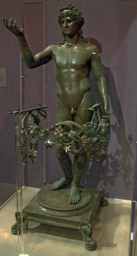 VII.16.17-22 Pompeii. Found 20th December 1960 near the “grande salone del casa”.
Statue of an Ephebus made into a lamp.
Now in Naples Archaeological Museum. Inventory number 13112.
See Sodo, A. M. (2005): Cibo e Luxus: in Cibi e Sapori a Pompei e dintorni, p. 52, fig. 17.
See Conticello, B., Ed, 1990. Rediscovering Pompeii. Rome: L’Erma di Bretschneider. (p. 257).