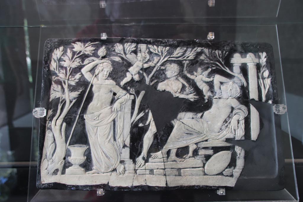 VII.16.17-22 Pompeii. October 2022.
Glass cameo panel decorating furniture and depicting Bacchus and Ariadne, on display in exhibition in Palaestra. Photo courtesy of Klaus Heese.