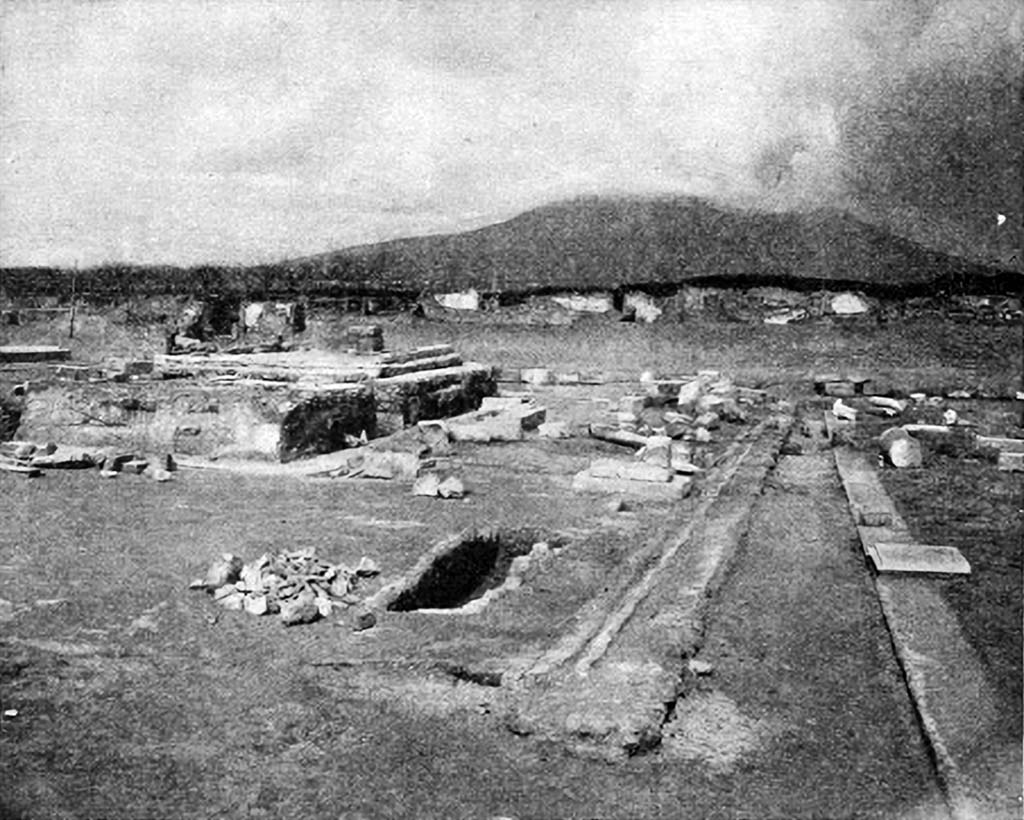 VIII.1.3 Pompeii. Mau Fig. 55. Ruins of the temple of Venus Pompeiana, viewed from the southeast.
At the right, foundation of the front row of columns of the latest (unfinished) colonnade; then foundation of stylobate of earlier colonnade, with gutter. In foreground, entrance to subterranean passage. On the podium of the temple at the farther end is seen the pedestal of the statue of the divinity. The wall at the rear of the court is on the south side of the Via Marina.
