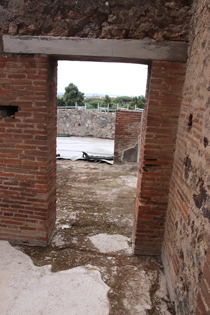 VIII.2.16 Pompeii. May 2024. Looking west in corridor.
Doorway from corridor in south-west corner of atrium, leading to room/cubiculum opening onto east portico.
Photo courtesy of Klaus Heese.