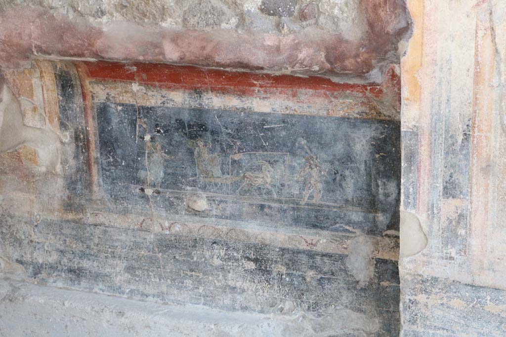 IX.1.7 Pompeii. December 2018.
Above the black zoccolo, in the predella is a painting showed a Psyche in a cart pulled by two goats and being led by a cupid, whilst another Psyche, wearing a green robe, followed it. Photo courtesy of Aude Durand.